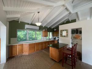 a large kitchen with wooden cabinets and a window at JJ's Getaway in Cruz Bay