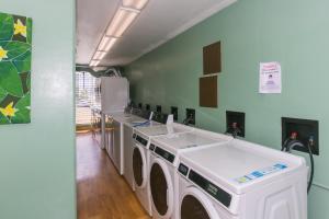 a laundry room with three washing machines in it at Ilikai Marina 1781 City View Studio in Honolulu