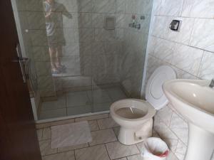 een badkamer met een douche, een toilet en een wastafel bij Ap duplo econômico, com banheiro, sem café ou TV no Espaço Verona in Fazenda Rio Grande