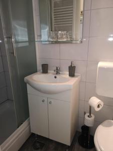 a white bathroom with a sink and a shower at City centre room in Zagreb