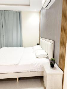 a bedroom with a white bed and a table at شقة جميلة مدخل جانبي دخول ذاتي 21 in Riyadh
