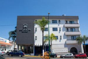 a building on a street with cars parked in front of it at Estanza Hotel & Suites in Morelia