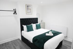 a bedroom with a large bed with green and white pillows at Modern & Spacious, Central Location, FREE PARKING, FREE WIFI in Liverpool