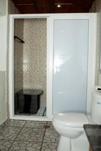 La salle de bains blanche est pourvue de toilettes et d'une cheminée. dans l'établissement KC GuestHouse, à Yaoundé