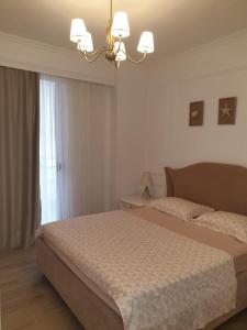 a bedroom with a bed and a chandelier at Saranda centre apt in Sarandë