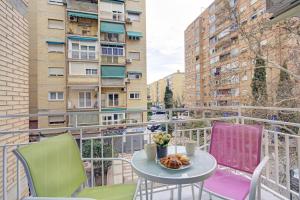 Apartamento en Fontiveros في غرناطة: شرفة مع كراسي وطاولة مع طبق من الطعام