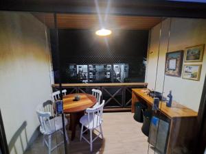 une salle à manger avec une table en bois et des chaises blanches dans l'établissement Monte Castelo Gravatá - Flat Aconchegante, à Gravatá