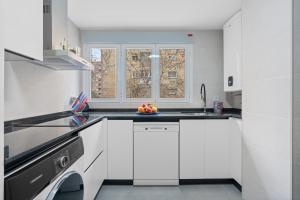 a white kitchen with a bowl of fruit on the counter at Apartamento en Fontiveros in Granada