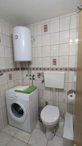 uma casa de banho com um WC e uma máquina de lavar roupa em Apartman PRESSTIGE em Smederevska Palanka