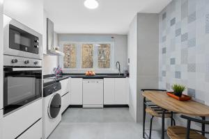 a kitchen with white appliances and a wooden table at Apartamento en Fontiveros in Granada +22 photos
