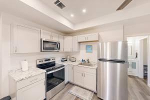 a kitchen with white cabinets and a stainless steel refrigerator at Denton Place Studio in Denton