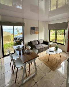 sala de estar con mesa y sofá en LakeLifeCR Tu casa frente al Lago Arenal, en Tilarán