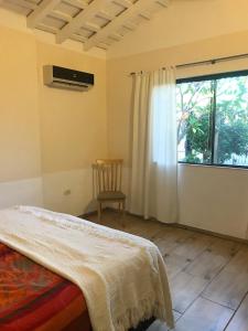 1 dormitorio con cama y ventana en Casa Loro en Caacupé