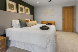 ein Schlafzimmer mit einem großen weißen Bett mit Handtüchern darauf in der Unterkunft 4A St Annes Well - Business, Leisure or Relocation in Exeter