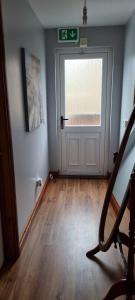an empty room with a door and a wooden floor at Cute loft apartment sleeps 4 in Antrim