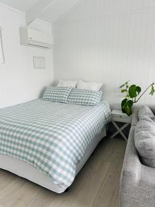 a bed with a checkered blanket in a bedroom at Hobbiton Pool House in Matamata