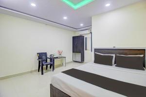 a bedroom with a bed and a desk with a chair at Super Collection O Hotel Mayur Inn in Hyderabad
