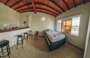 een slaapkamer met een bed en een keuken met krukken bij Hacienda Nápoles y Santorini Agradable y Fresco Apto in Doradal