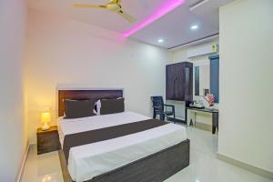 a hotel room with a bed and a desk with a ceiling fan at Super Collection O Hotel Mayur Inn in Hyderabad