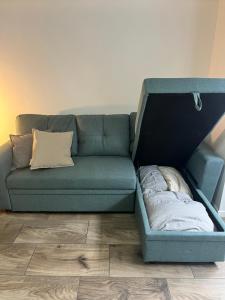 a blue couch with a bed in the middle of a room at Pavillion on Brookes in Brisbane