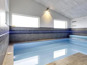 a swimming pool in a bathroom with two windows at 16 person holiday home in V ggerl se in Marielyst