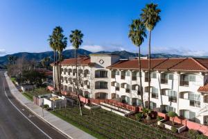 a building on the side of a street with palm trees at Santa Ynez Valley Marriott in Buellton