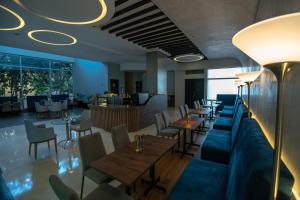 a restaurant with tables and chairs and a couch at GHL Hotel Barranquilla in Barranquilla