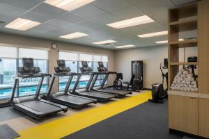 a gym with rows of treadmills and a swimming pool at TownePlace Suites by Marriott Georgetown in Georgetown