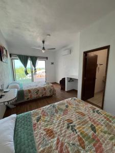 1 dormitorio con 2 camas, escritorio y ventana en Villas las Palmeras Casa Canaria 12 personas, en La Manzanilla