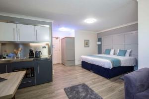 a hotel room with a bed and a kitchen at Best Western Manor Hotel in Gravesend
