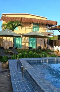 um resort com uma piscina com guarda-sóis em POUSADA AMAR NORONHA em Fernando de Noronha