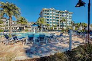 a pool with chairs and a hotel in the background at Carolina Beach Club, Unit 126 in Hilton Head Island