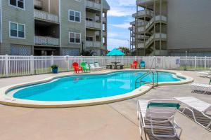 a large swimming pool with chairs and a table at Bayview Beach Escape in Pensacola Beach