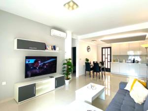 a living room with a couch and a tv on a wall at Precioso apartamento a tan solo 300 m de la playa in Pilar de la Horadada