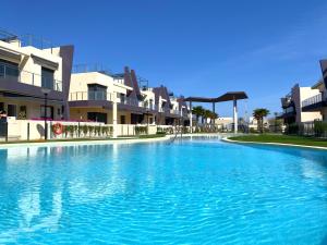 a large pool of blue water in front of buildings at Precioso apartamento a tan solo 300 m de la playa in Pilar de la Horadada