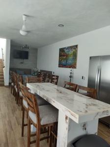 una cocina con una gran mesa de mármol blanco y sillas en Villas las Palmeras Casa Canaria 12 personas, en La Manzanilla