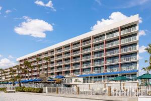 un grand bâtiment d'hôtel avec des parasols en face de celui-ci dans l'établissement DoubleTree Beach Resort by Hilton Tampa Bay – North Redington Beach, à St. Pete Beach