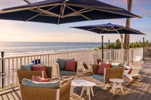 una terraza con sillas y sombrillas en la playa en DoubleTree Beach Resort by Hilton Tampa Bay – North Redington Beach, en St Pete Beach