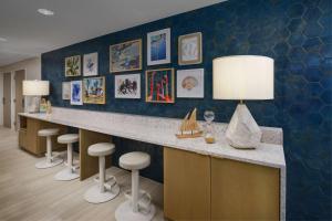 a lobby with a counter with stools and paintings at DoubleTree Beach Resort by Hilton Tampa Bay – North Redington Beach in St Pete Beach +42 photos