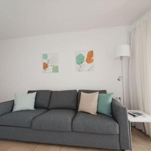 a living room with a gray couch with pillows at Central Flat Puerto del Carmen in Puerto del Carmen