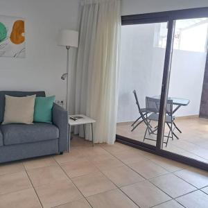 a living room with a couch and a table at Central Flat Puerto del Carmen in Puerto del Carmen +24 photos
