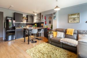 Rambler’s Retreat في Dersingham: غرفة معيشة مع أريكة ومطبخ