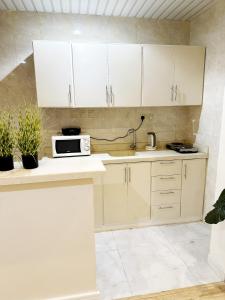 a kitchen with white cabinets and a sink at The Trees شقة جميلة مدخل خاص دخول ذاتي in Riyadh