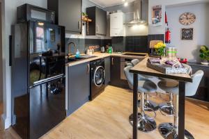 Dersingham的住宿－Rambler’s Retreat，厨房配有洗衣机、烘干机和桌子