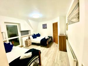 a bedroom with two beds with blue pillows at Cozy One Bedroom Flat Free Car Park In Central London in London