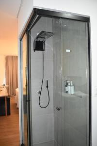 a shower in a room with a glass door at POUSADA AMAR NORONHA in Fernando de Noronha