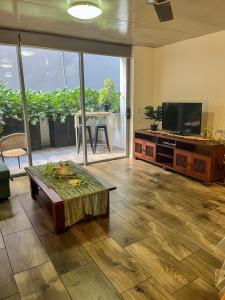 een woonkamer met een tafel en een flatscreen-tv bij Pavillion on Brookes in Brisbane