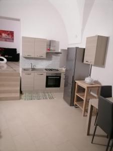 a kitchen with a stainless steel refrigerator and a table at Lips House in Gravina in Puglia
