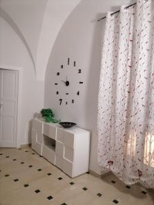 a clock on a wall in a living room at Lips House in Gravina in Puglia