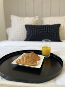 uma bandeja com um prato de pastelaria e um copo de sumo de laranja em Modern 2 Bedroom Home in Edinburgh Free Parking em Edimburgo